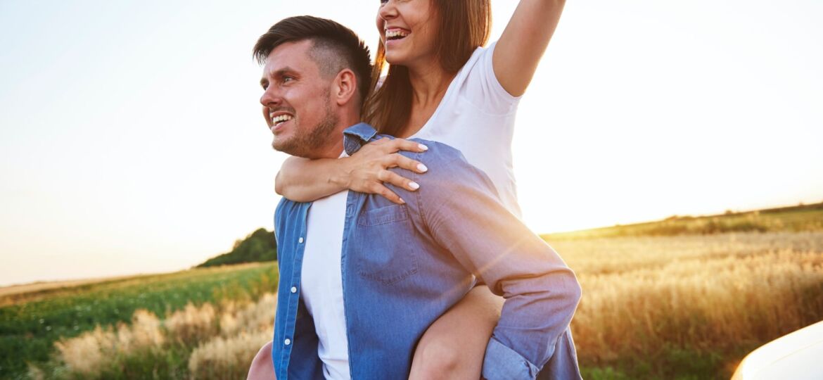 young-man-carrying-girlfriend-on-his-shoulders-JUFAFGM 2